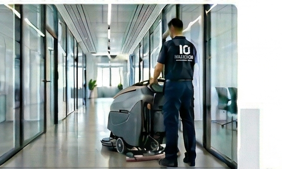 Inside OUT cleaner operating a floor machine in a commercial hallway